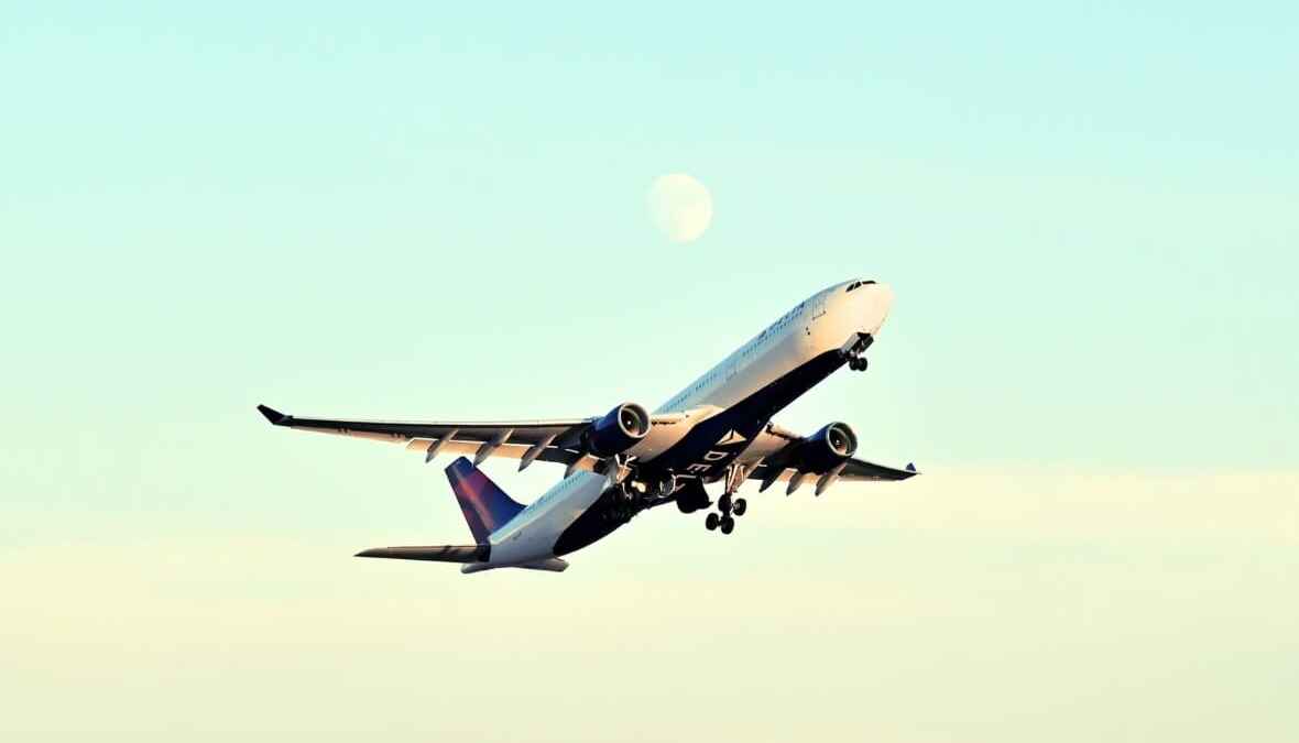 Flugzeug von Delta Airlines hebt ab, Mond im Hintergrund.