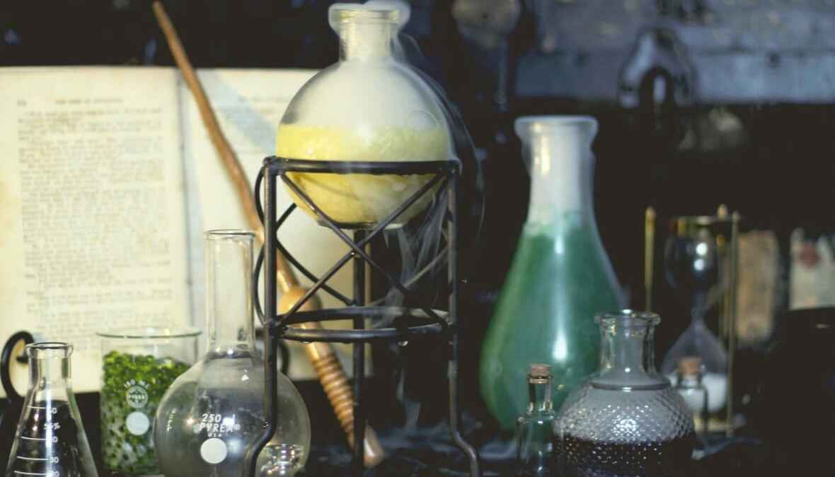 Laborgeräte mit dampfendem Kolben und grüner Flüssigkeit, mysteriöses Alchemie-Setup.