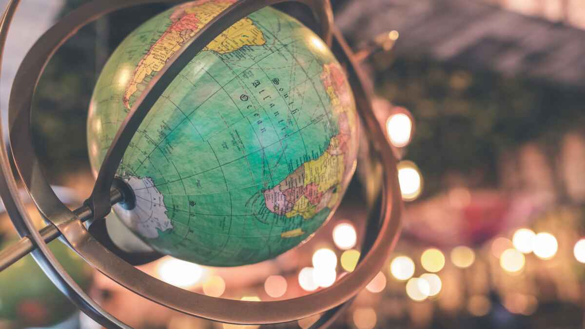 Nahaufnahme eines Globus mit sichtbarem Lateinamerika, umgeben von unscharfen Lichtern im Hintergrund.