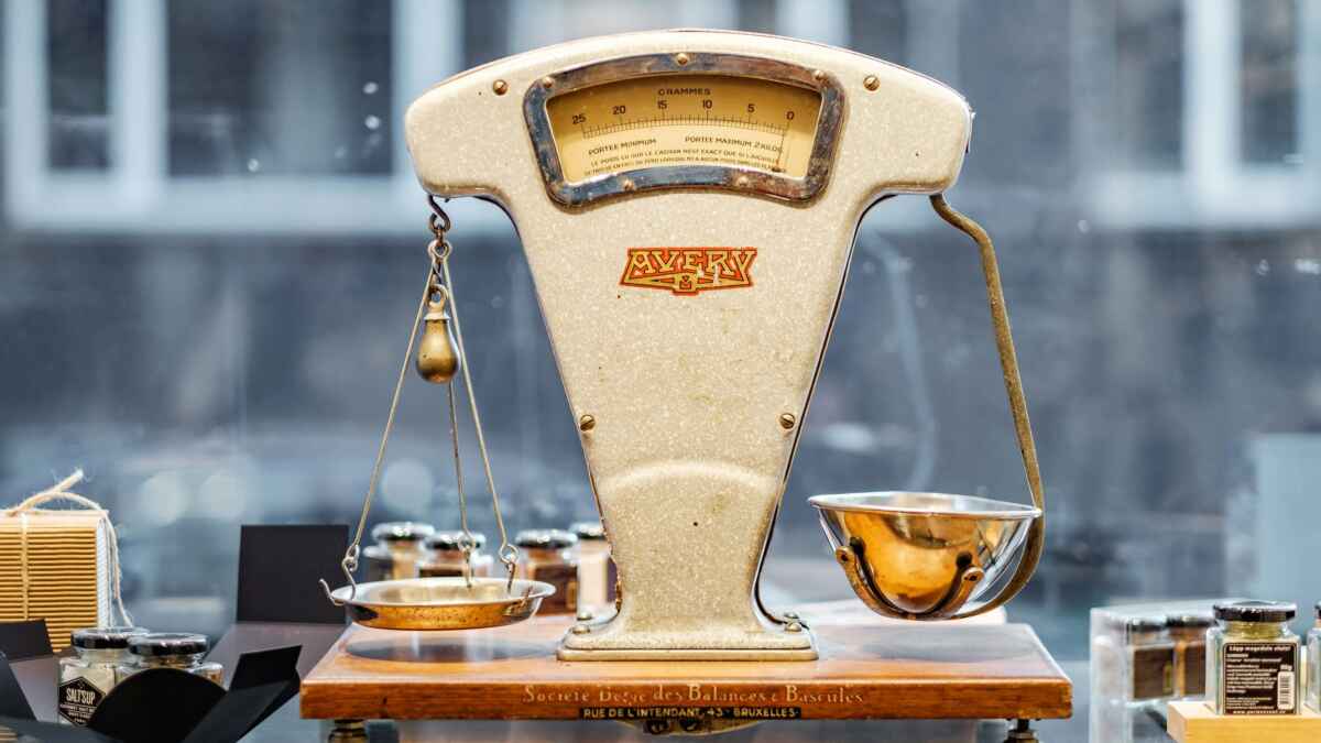 Vintage Avery Waage aus Metall in einem Schaufenster mit Produkten im Hintergrund.